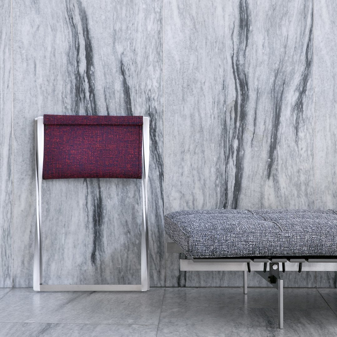 Modern chair with a deep burgundy patterned seat against a sleek gray marble backdrop. Elegant and minimalist design.