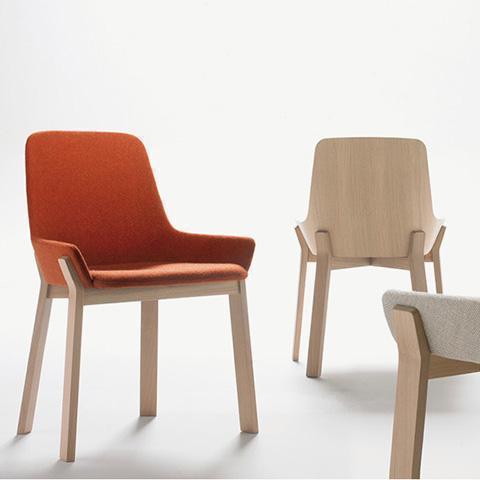 "Modern chairs featuring a warm orange fabric seat and natural wood legs, complemented by neutral tones in the background."