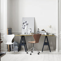 Modern desk setup featuring a brown and white chair, gold and navy accents, with a minimalist color scheme.