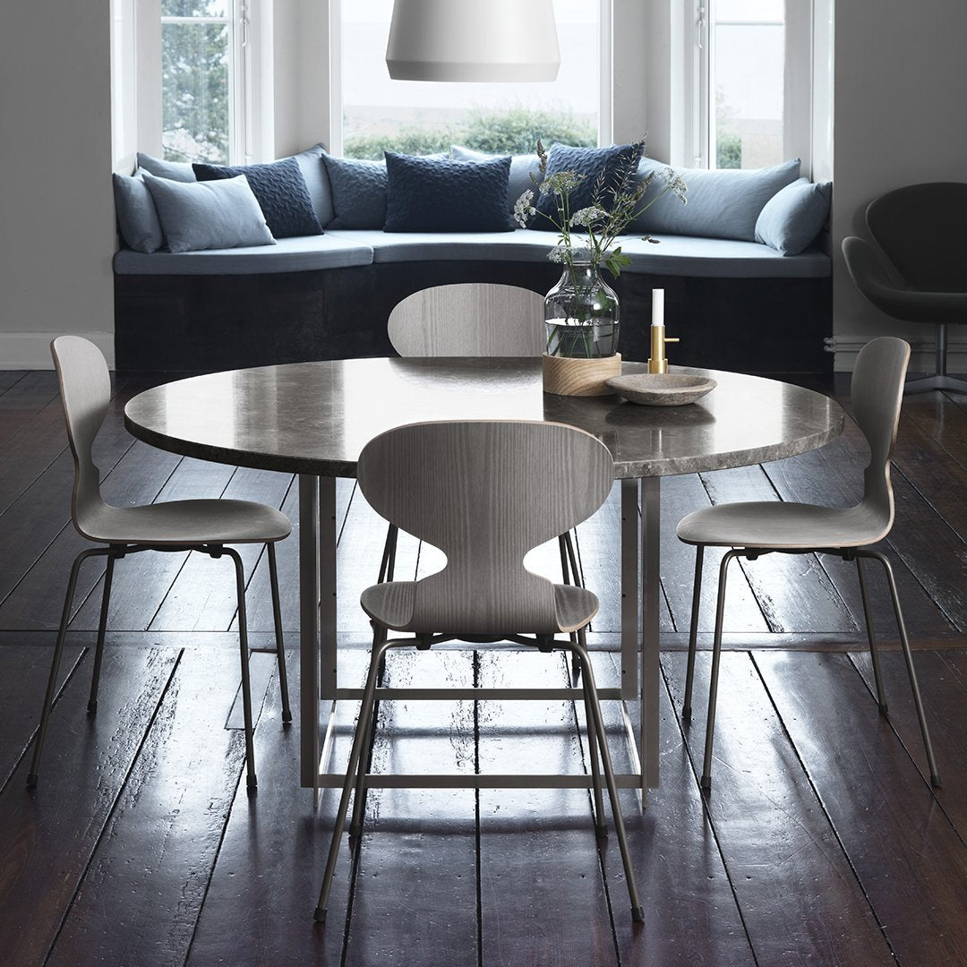 Elegant round gray marble dining table with light wooden chairs, featuring a calm and modern color palette.