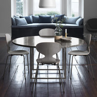Elegant round gray marble dining table with light wooden chairs, featuring a calm and modern color palette.