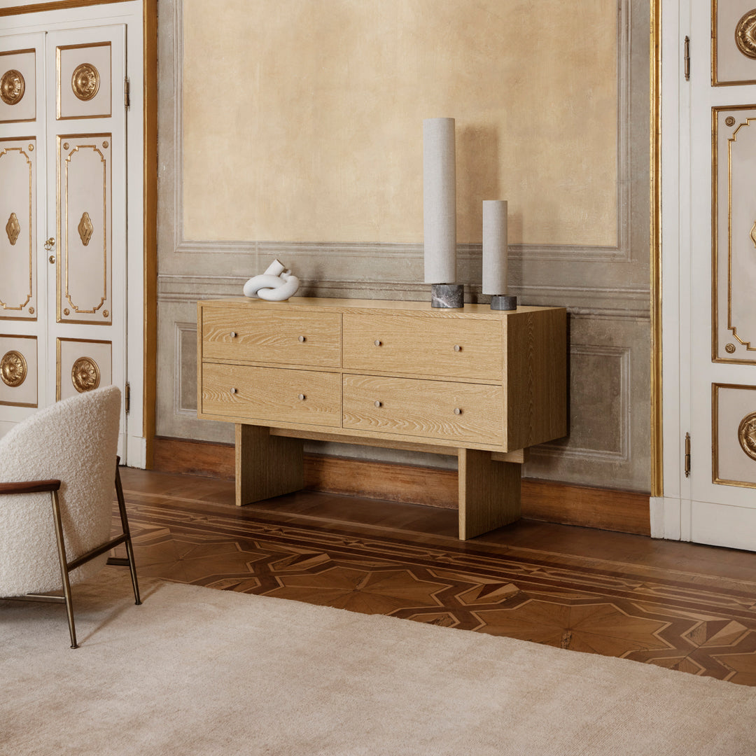 Light oak sideboard with a minimalist design, featuring smooth surfaces and subtle grain patterns, set in an elegant room.