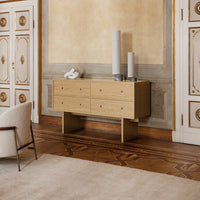 Natural wood sideboard in light beige with six drawers, complemented by neutral decor and soft textures.