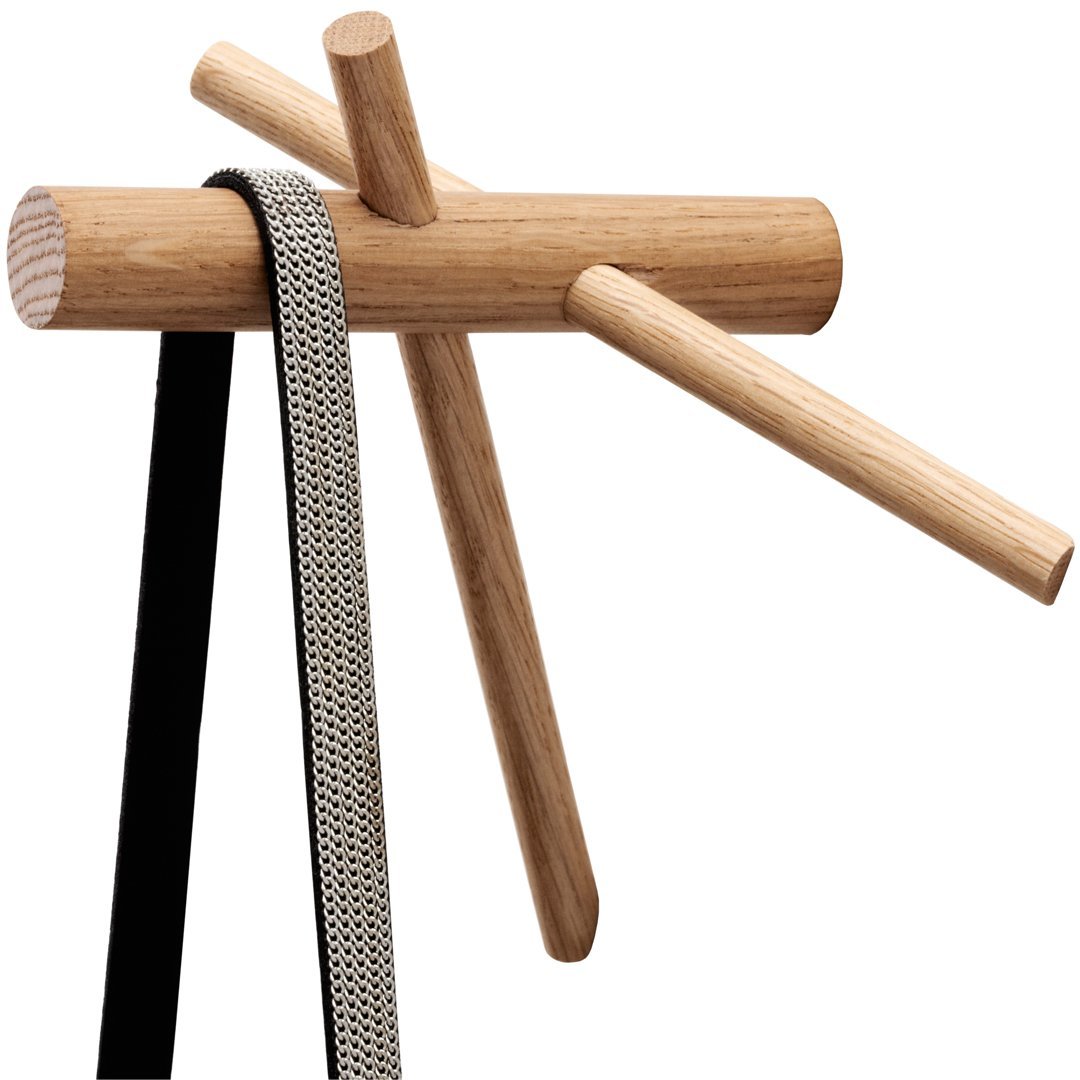 Wooden coat rack with natural oak finish, featuring black and white patterned straps. Modern, minimalist design.