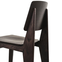 Dark wood chair with a minimalist design and a textured light gray seat, highlighting modern aesthetic patterns.