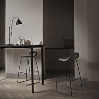 "Stylish black wire bar stools against a muted, neutral-toned backdrop, showcasing minimalist modern design."
