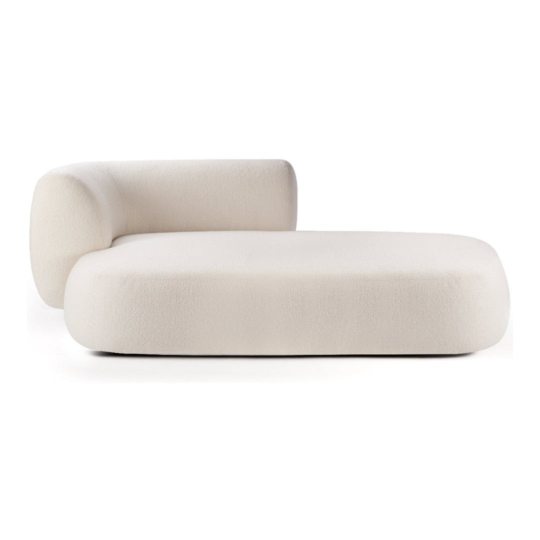 Cream-colored modern chaise lounge with smooth, minimalist design and curved shapes. Perfect for contemporary decor.