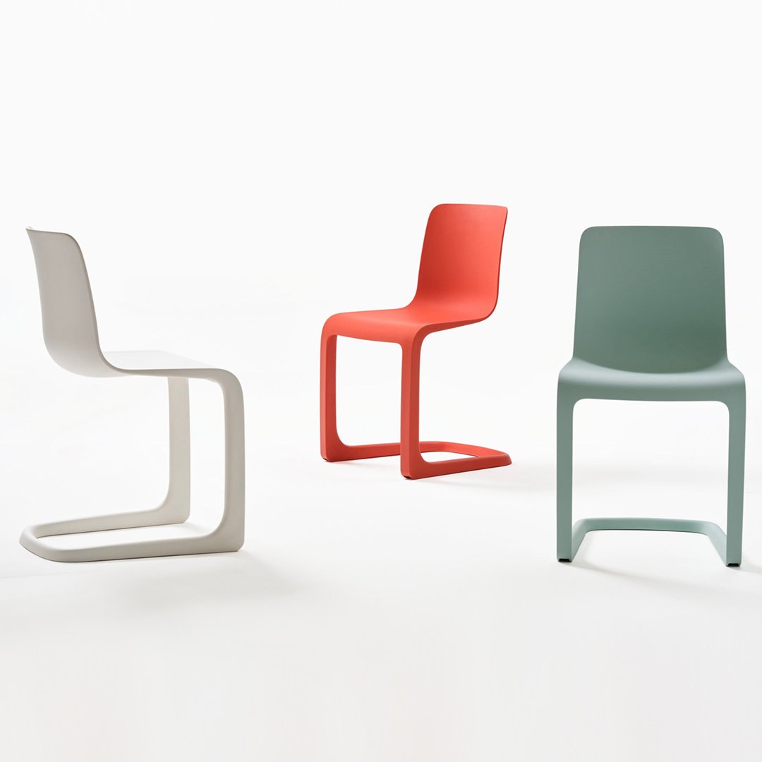 Colorful modern chairs in white, coral, and mint green with smooth, minimalist designs. Ideal for contemporary spaces.