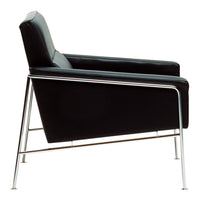 Black leather armchair with sleek chrome legs, featuring a minimalist design and smooth, modern lines.