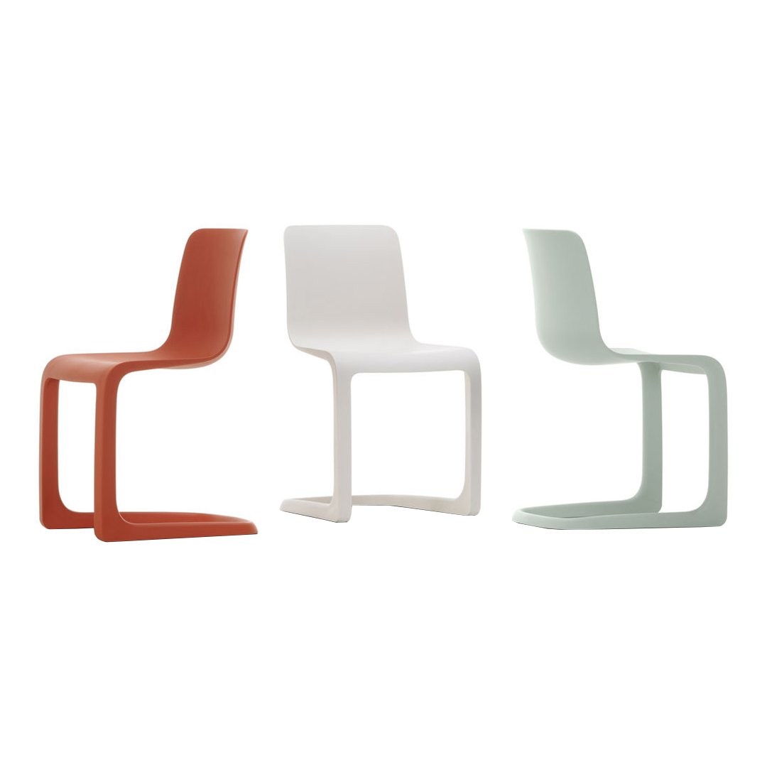 Set of three sleek modern chairs in coral, white, and soft mint green, showcasing a minimalist design.