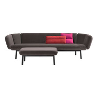 Modern gray sofa with vibrant pink and red accent cushions, featuring a sleek design and minimalist style.