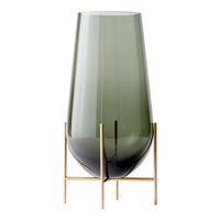Green tinted glass vase with a sleek design, featuring a smooth finish and mounted on a stylish gold stand.