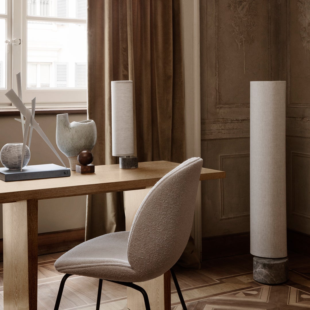 Elegant beige table lamp with textured cylindrical design, complementing soft neutral decor tones and geometric patterns.