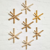"Set of wooden wall decor in natural shades, featuring various light and medium finishes and geometric star patterns."