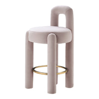 Pastel pink velvet stool with rounded edges and a gold circular footrest, showcasing minimalist design and soft textures.