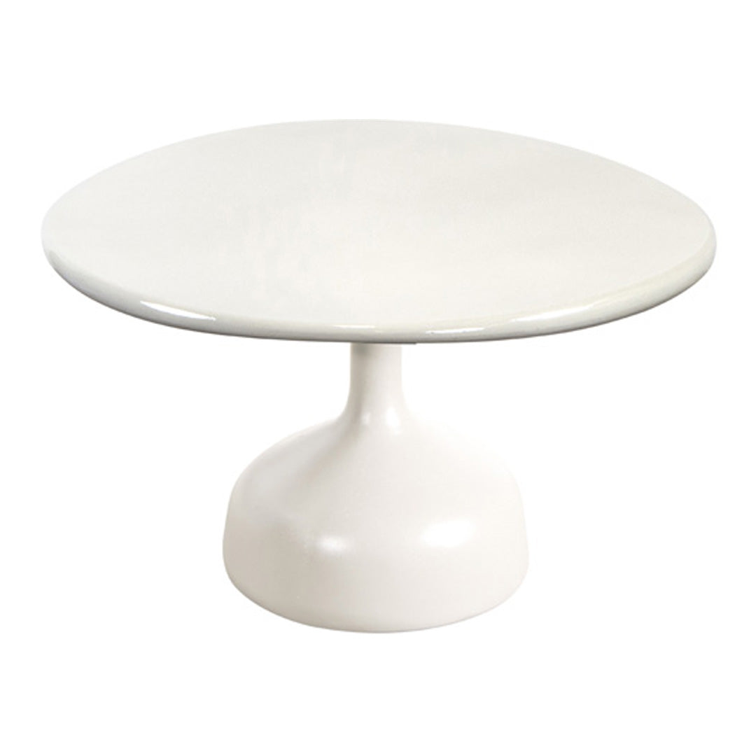 Round white dining table with a glossy finish and a sleek pedestal base. Perfect for modern interiors.