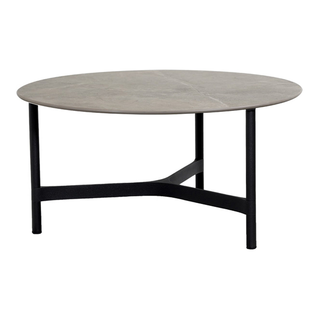 Round coffee table with a light gray top and black metal legs, featuring a smooth, minimalist design.