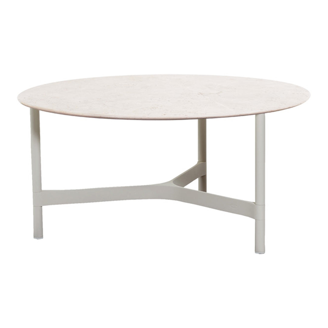Round coffee table with a light beige top and a sleek gray base, featuring a smooth, minimalist design.