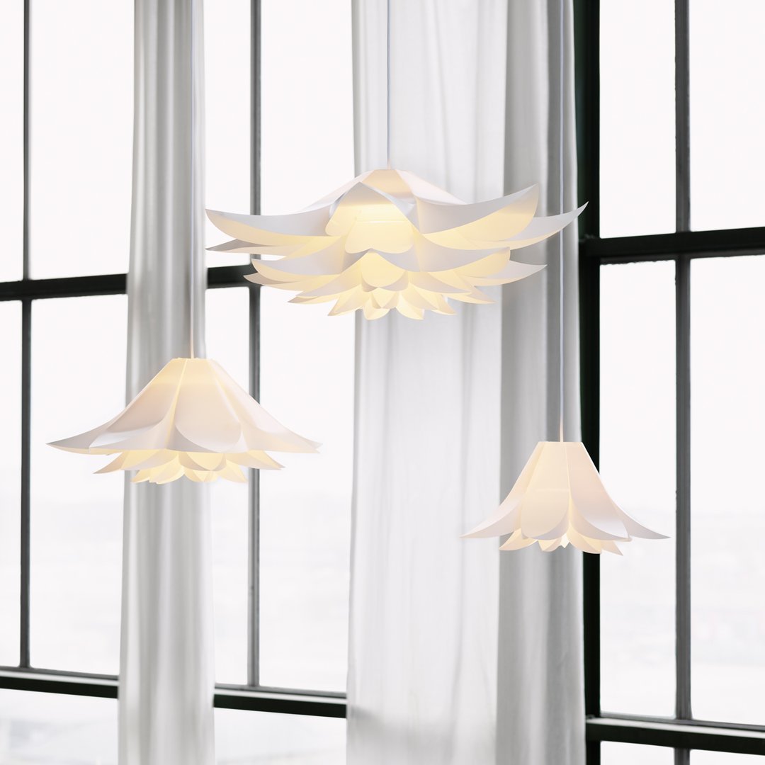 "Elegant white floral pendant lights with layered petal design, set against sheer white curtains and bright windows."