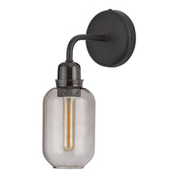 Black wall sconce with a clear glass shade and vintage-style filament bulb, featuring sleek, modern lines.