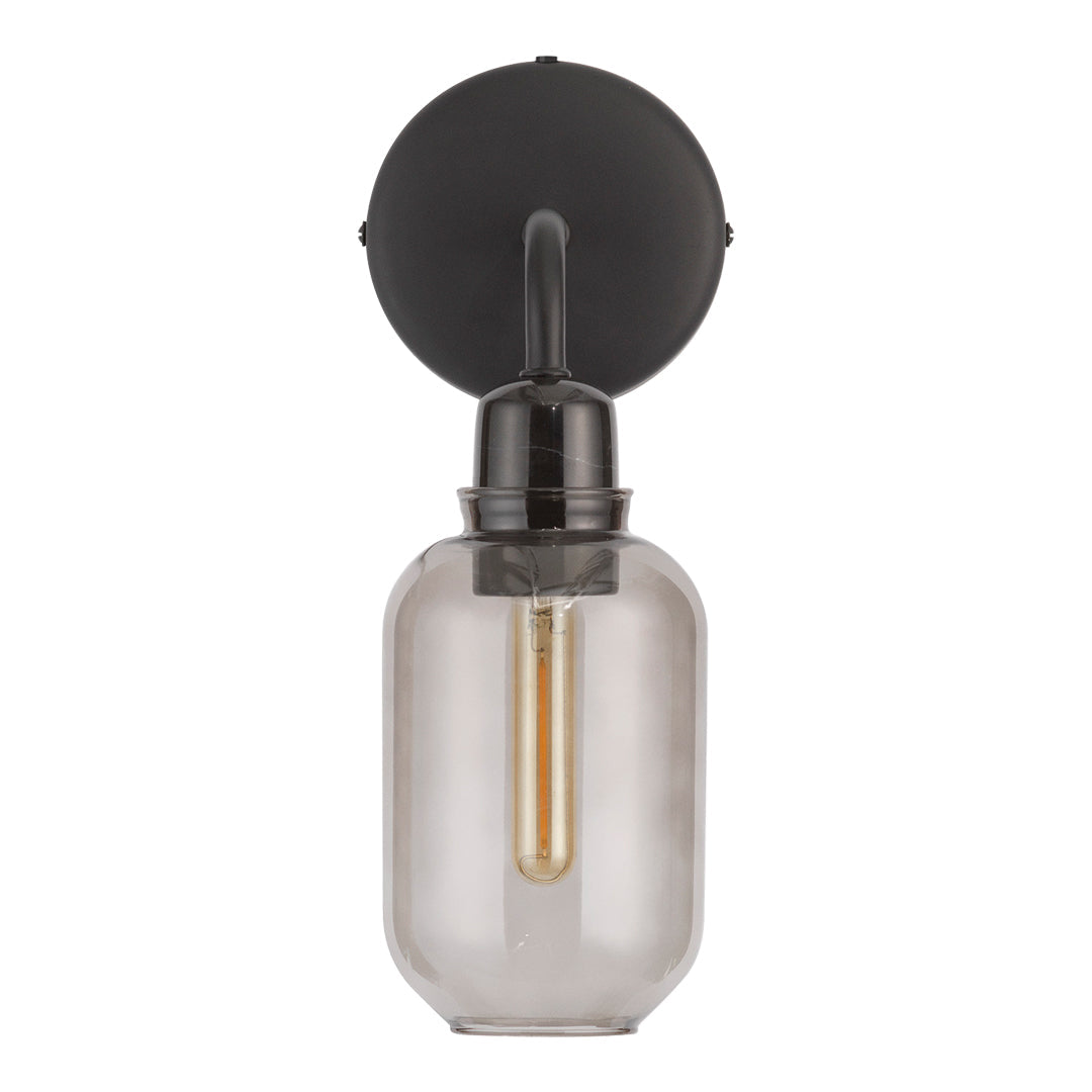 Black wall-mounted light fixture with a clear glass shade and warm gold bulb. Modern, minimalist design.