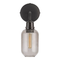 Black wall-mounted light fixture with a clear glass shade and warm gold bulb. Modern, minimalist design.