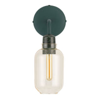 Green wall mount light fixture with a round base, clear glass shade, and a warm yellow filament bulb.