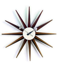 Mid-century modern starburst clock with brown wooden spikes and a white circular face. Stylish retro wall decor.