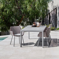 Stylish outdoor dining set with gray metal table and brown woven chairs, perfect for modern patios.