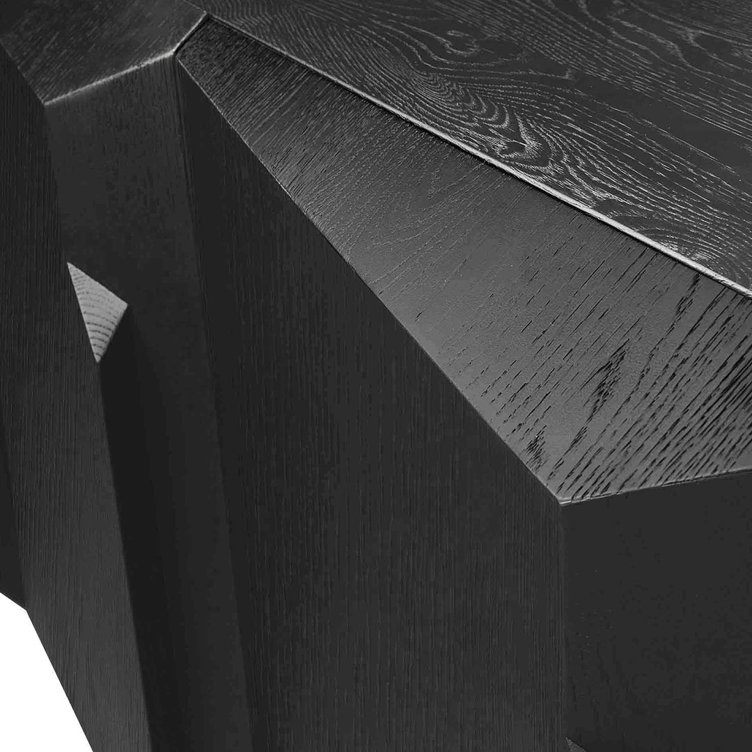 Geometric black wood table surface with a textured finish and sharp angles, showcasing modern minimalist design.