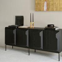 Modern black cabinet with geometric patterns, complemented by minimalist decor in a neutral setting.