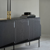 Elegant dark wood sideboard with subtle grain patterns, paired with sleek black and gold decorative accents.