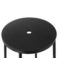 Black round stool top with a smooth finish and a center hole, complemented by slender black legs.