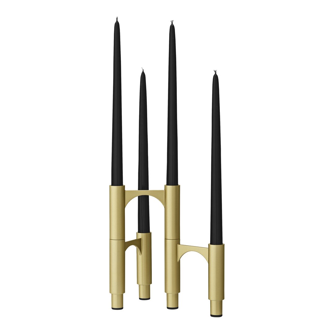 Gold candle holder with three tall black candles, featuring a sleek, modern design and simple geometric shapes.