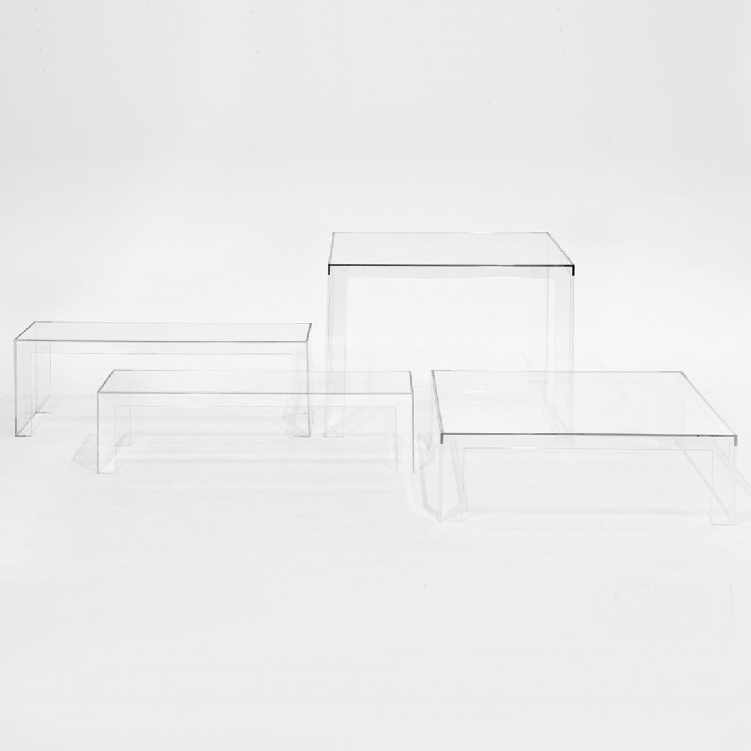 Clear acrylic nesting tables with a minimalist design, showcasing a sleek, transparent finish and angular shapes.