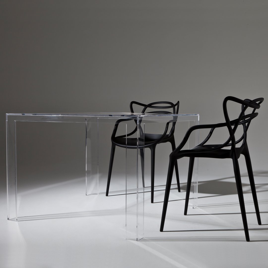 Black modern chairs with transparent acrylic table, featuring minimalist design and sleek, contemporary lines.