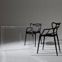 Black modern chairs with transparent acrylic table, featuring minimalist design and sleek, contemporary lines.