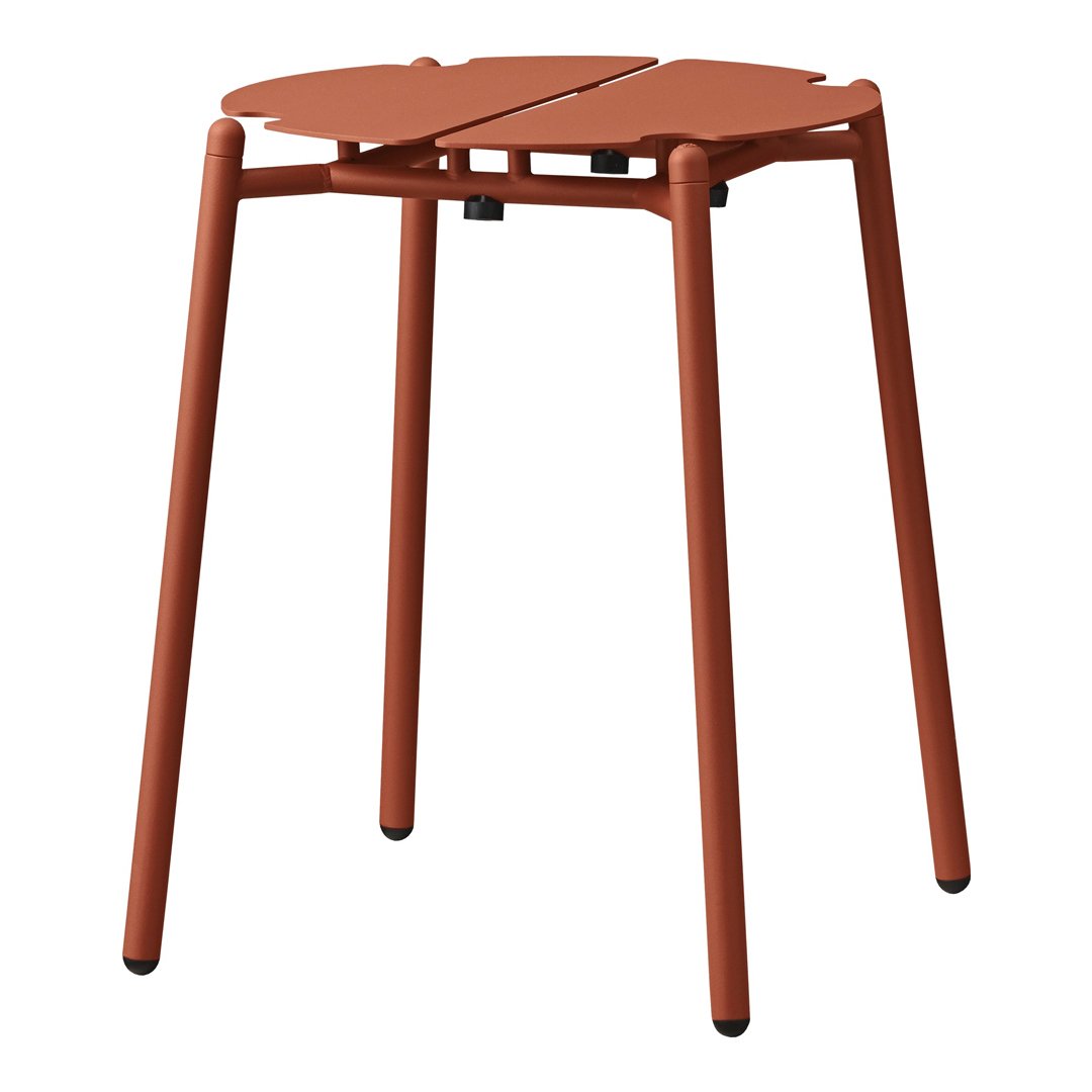Rust-colored stool with a modern, minimalist design, featuring a unique leaf-shaped pattern on the top.