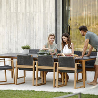 Stylish outdoor dining set featuring natural wood, sleek black cushions, and a modern minimalist design.