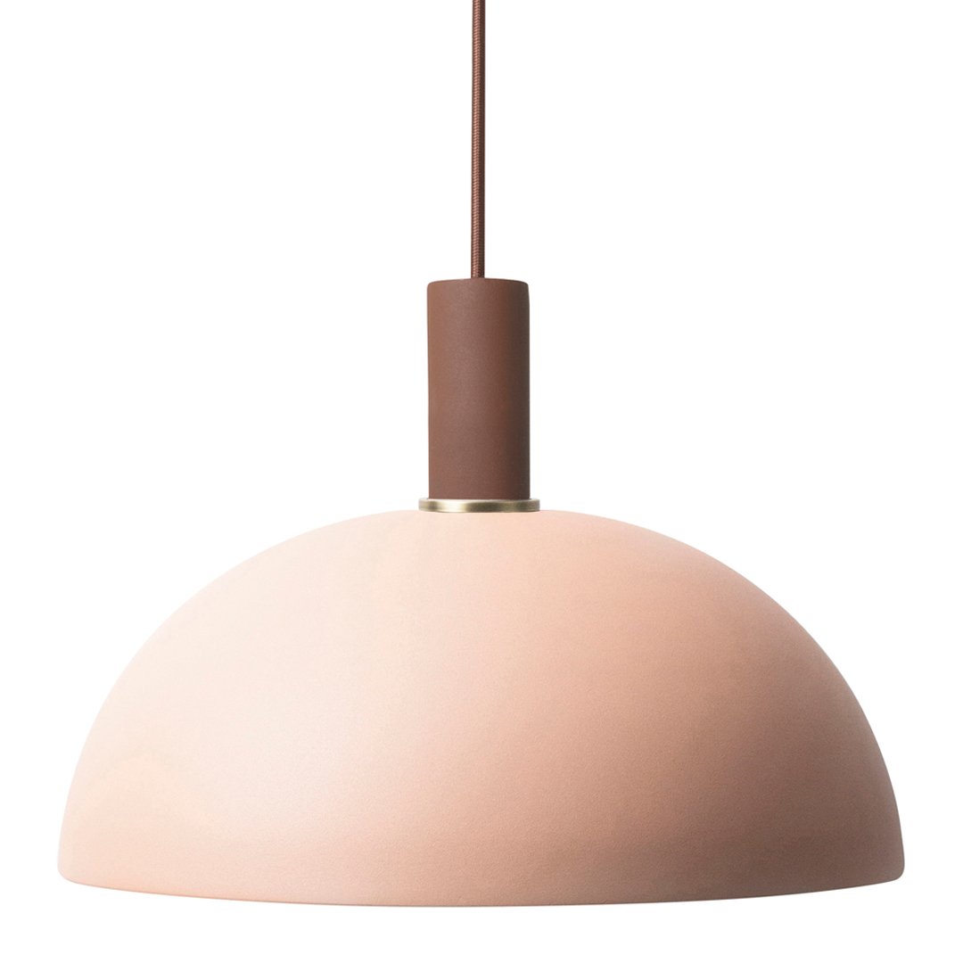 Soft pink dome pendant light with a brown mount, creating a modern and minimalistic aesthetic.