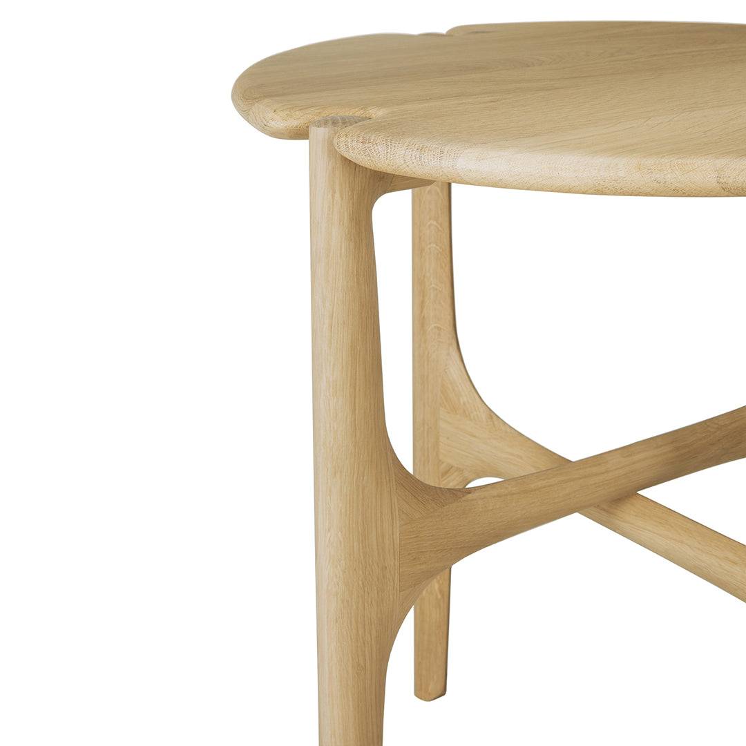 Light natural wood finish with a smooth, rounded tabletop and sculpted legs for a modern design.