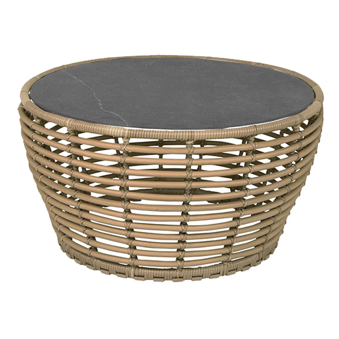 Round woven coffee table with a natural tan base and a sleek black stone top, featuring a unique basketweave pattern.