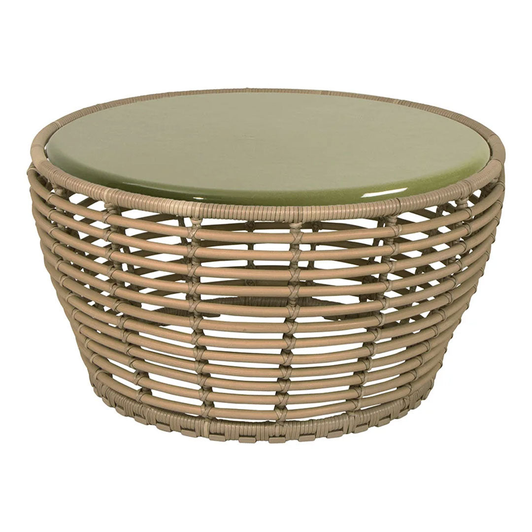 Round wicker coffee table with natural tan tones and a smooth green glass top, featuring an open weave pattern.