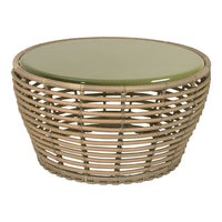 Round wicker coffee table with natural tan tones and a smooth green glass top, featuring an open weave pattern.