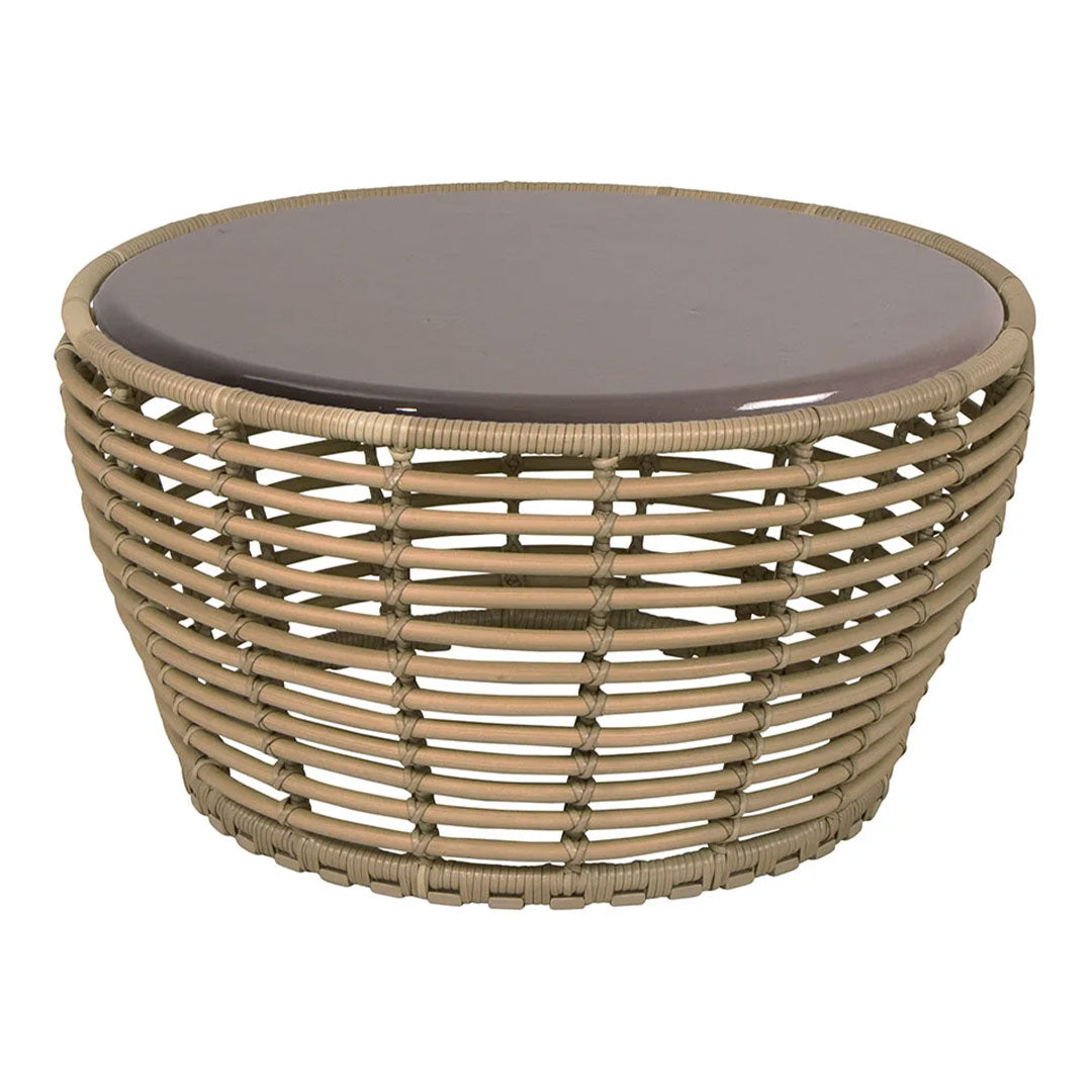 Round wicker coffee table in natural tones with a smooth, dark brown glass top. Stylish lattice pattern design.