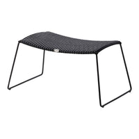 Black striped outdoor ottoman with sleek metal frame, ideal for modern patio decor.