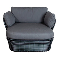 Stylish gray upholstered chair with black woven base and matching arm cushions, perfect for modern decor.