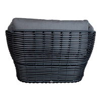 Black woven basket with a gray cushion, featuring a sleek, modern design. Ideal for stylish home organization.