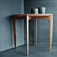 Modern wooden table with a natural finish, complemented by gray and metallic accents. Minimalist design and clean lines.
