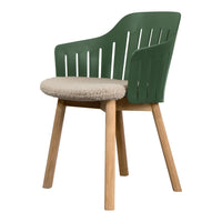 Green plastic chair with a textured beige cushion and natural wood legs, featuring a modern, slatted design.